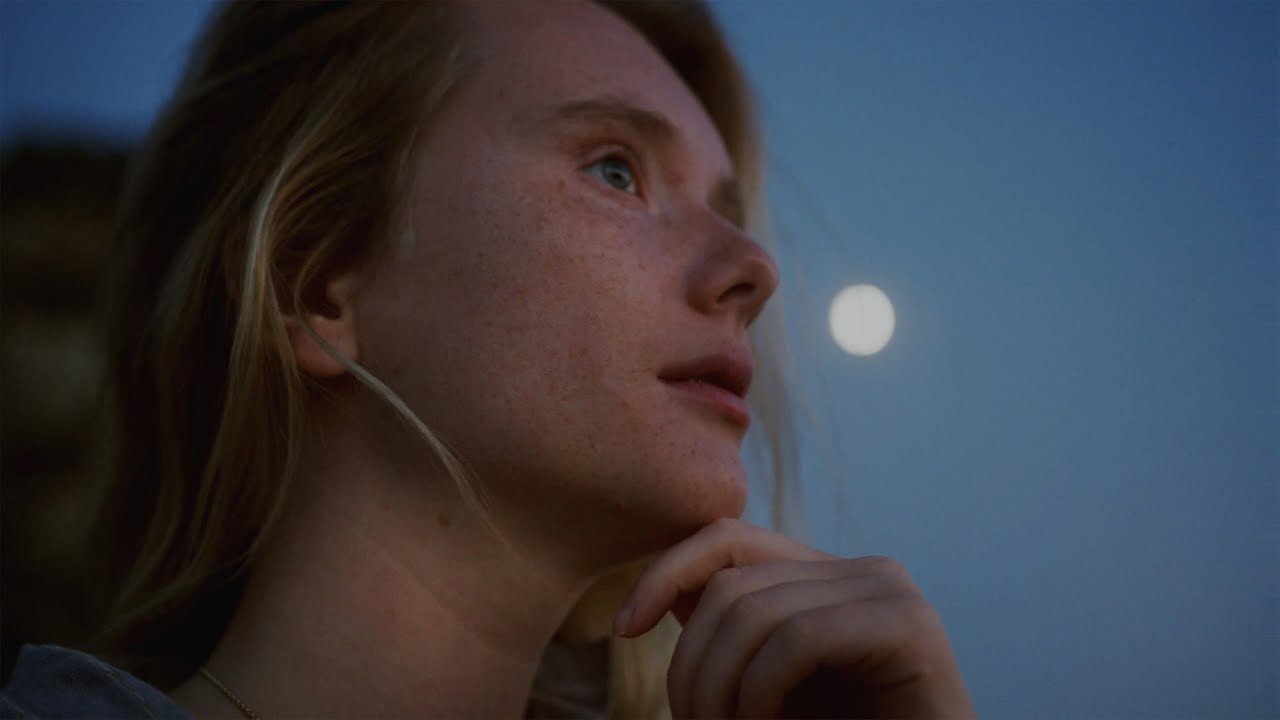OBSYDN, Neptune official video: a woman looking up at the full moon at dusk